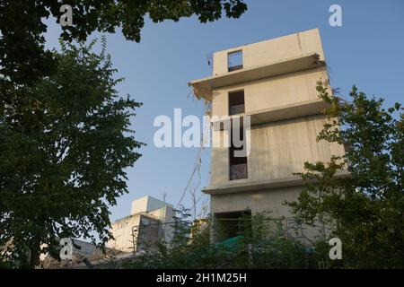 Détruit un grand bâtiment en béton en cours de démolition. Angle plus large avec des bâtiments en béton industriel en arrière-plan. Soleil matinal, ciel doux Banque D'Images