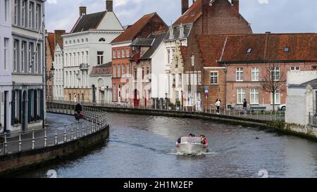 Bruges / Belgique - 03-08-2020: Bateau avec touristes sur le canal et les bâtiments derrière Banque D'Images