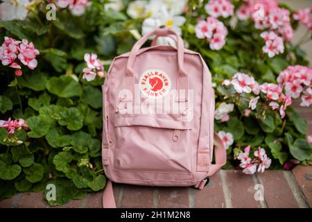Londres, Royaume-Uni - 4 novembre 2020 : petit sac à dos Fjallraven rose sur jardinière en briques avec plantes et fleurs roses.Sac à dos rose et fleurs colorées sur bri Banque D'Images