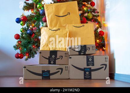 Calgary, Alberta, Canada. 16 novembre 2020. Boîtes et enveloppes Amazon sous un sapin de Noël avec ornements et lumières allumés. Concept : livraison de packages Banque D'Images