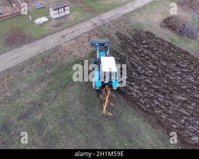 Le tracteur laboure le jardin. Labourer le sol dans le jardin. Banque D'Images