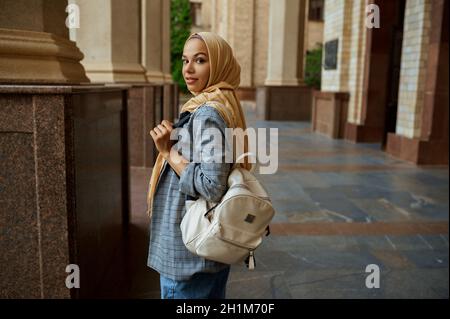 Étudiante arabe avec des livres à l'entrée de l'université. Une femme musulmane dans le hijab tient des manuels en plein air. Banque D'Images