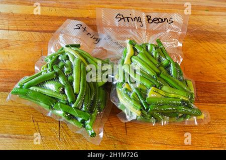 Deux paquets de haricots verts frais scellés sous vide dans des sacs. Banque D'Images