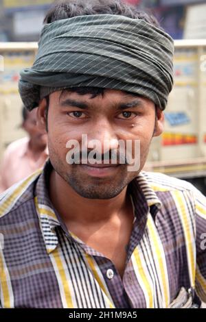 Un pilote indien de pousse-pousse pose assis sur un pousse-pousse tricycle à Kolkata, en Inde Banque D'Images