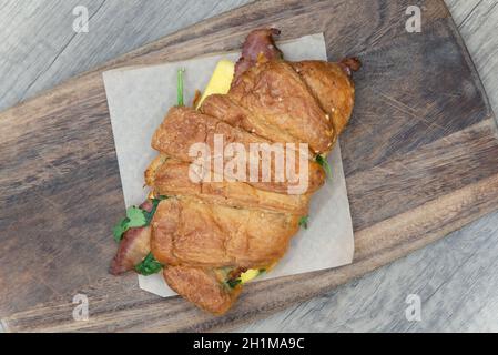 Vue sur le dessus du bacon et des œufs servis à l'intérieur d'un petit déjeuner croissant pour un sandwich à emporter. Banque D'Images