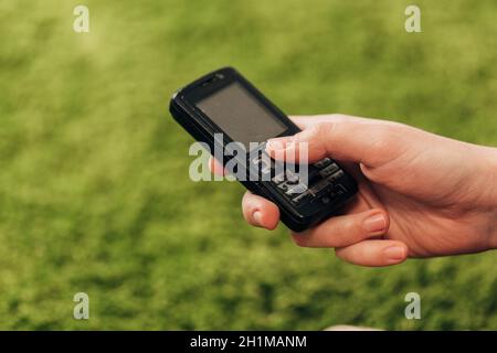 Fille tient un vieux téléphone bouton dans sa main. Banque D'Images