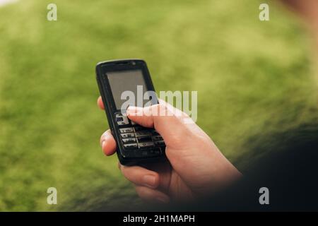 Fille tient un vieux téléphone bouton dans sa main. Banque D'Images