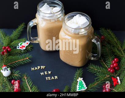 Marshmellou le cacao, l'arbre de Noël avec des décorations sur un fond noir. L'inscription Bonne Année. Banque D'Images