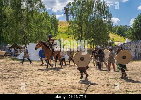 Cedynia, Pologne, juin 2019 Chieftain à cheval et ses guerriers attaquent fort avec Czcibor Mountain en arrière-plan.Reconstitution historique de la bataille de Banque D'Images