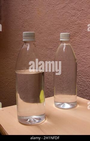 Étude de deux bouteilles en verre remplies d'eau tableau sur fond marron granuleux Banque D'Images