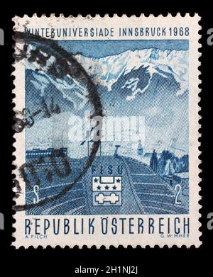 Timbre émis à l'Autriche montre Berg Isel-ski jump avec vue sur la chaîne de montagnes du nord, de l'Université d'hiver de 2010 à Innsbruck, vers 1968. Banque D'Images