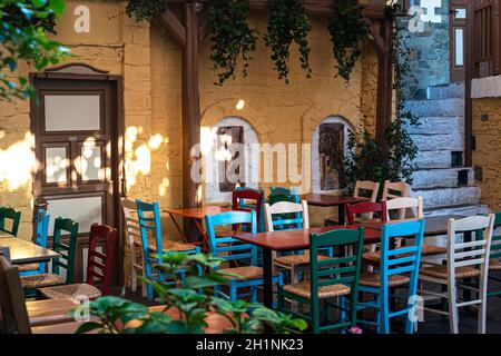 Chaises et tables colorées dans un café sur les escaliers publics de Yiasemi pour dîner dehors à Athènes, Grèce pendant l'été Banque D'Images