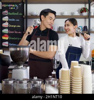Le commerçant et le barista tiennent les porte-filtres Espresso machine avec un sourire. Ambiance matinale dans un café. Banque D'Images
