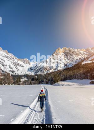 Girl est une promenade sur un sentier enneigé, idyllique paysage d'hiver avec vue imprenable sur la montagne, paysage de neige et ciel bleu Banque D'Images