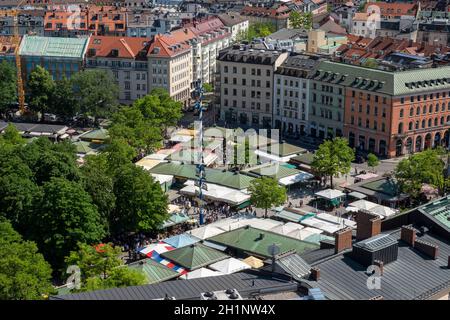 Vue de la Tour de l'église Alter Peter au marché alimentaire traditionnel Viktualienmarkt avec May Pole et les stands du marché - Munich Banque D'Images