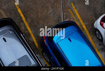 Vue de dessus de la voiture garée sur le parking en béton avec ligne jaune de signalisation sur la rue. Vue au-dessus de la voiture dans une rangée à l'espace de stationnement. Pas d'ava Banque D'Images