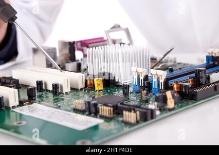 Ingénieur en informatique travaillant sur une vieille carte mère Banque D'Images