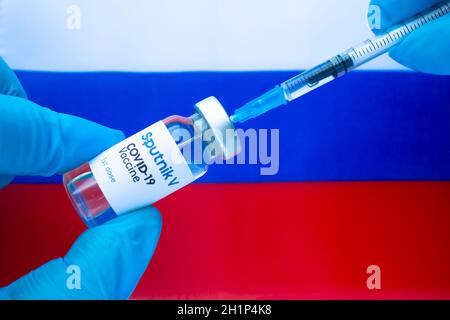 Calgary (Alberta). Canada. 20 janvier 2021. Un agent de santé avec un vaccin Spitnik V et une seringue avec un drapeau russe sur le fond Banque D'Images