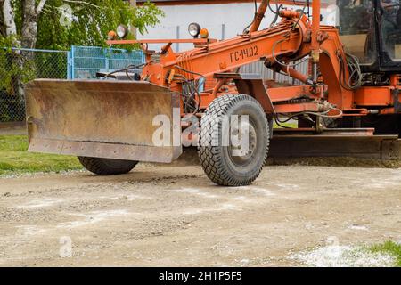 Krasnodar, Russie - 19 avril 2018 : niveleuse sur une route de gravier de terre.Réparation de rue en ajoutant des gravats. Banque D'Images