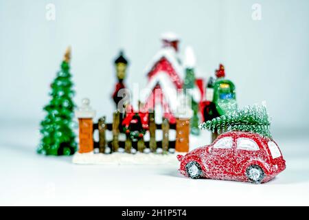 Gros plan sur une voiture rouge avec un arbre de Noël sur le toit pour rentrer à la maison. Banque D'Images
