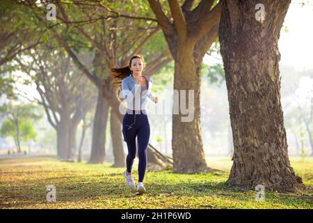 belle jeune femme qui court dans le parc le matin Banque D'Images