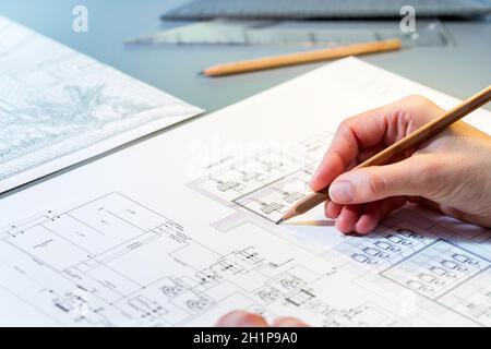 Gros plan macro des arpenteurs de la quantité passant en revue manuellement le dessin technique. Banque D'Images