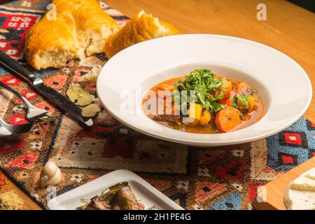 Soupe géorgienne chaude et épicée et bouillon de poulet avec herbes et épices sur l'assiette.Plat national géorgien fait maison.Concept - menu pour un restaurant Banque D'Images