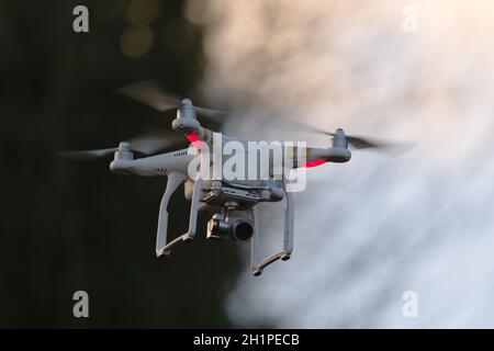 Great Malvern, Royaume-Uni, 27 décembre, 2020: Drone caméra à télécommande quadcopter volant dans le ciel du soir. Arrière-plan clair et flou de mouvement Banque D'Images