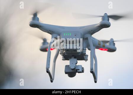 Great Malvern, Royaume-Uni, 27 décembre 2020: Vue arrière d'un drone quadcopter blanc avec des lumières, contre le ciel bleu du soir. Hélice de flou de mouvement Banque D'Images