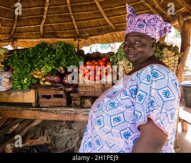 BAMAKO, MALI - VERS FÉVRIER 2012: Femme malienne vendant des légumes sur le côté de la route. Banque D'Images