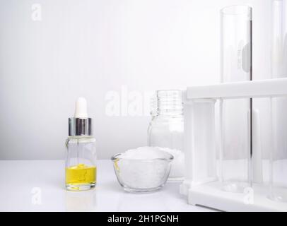 Ingrédients chimiques cosmétiques sur table blanche de laboratoire. Éthanolamine, acide, alcool cétylique, couleur cosmétique jaune (huile), cire microcristalline Banque D'Images