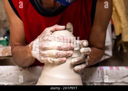 Homme faisant des articles en céramique sur la roue de potiers dans un Usine traditionnelle dans la ville de Ráquira située dans le département de Cundinamarca en Colombie Banque D'Images