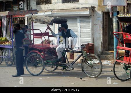 Des pilotes de pousse-pousse à vélo attendent des clients dans les rues de Delhi, en Inde Banque D'Images