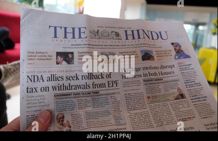 Un homme lit le journal indien The Hindu dans le hall de l'hôtel à Delhi, en Inde Banque D'Images