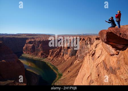 Les touristes à la recherche à 1000 ft tomber à la rivière Colorado à Horseshoe Bend, juste en dehors de Grand Canyon, près de Page, Arizona, USA Banque D'Images