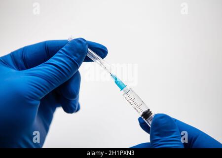 Main du médecin dans des gants bleus en préparation pour la vaccination. Coronavirus, vaccin contre le covid-19 Banque D'Images