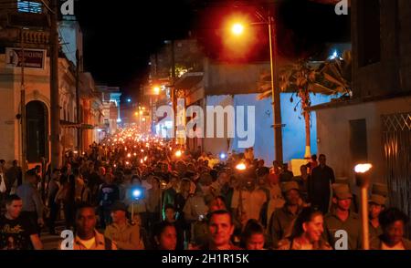 Santa Clara, Cuba - 27 janvier 2019 : Des milliers de personnes marchant dans la rue, tenant dans leurs mains des flambeaux allumés la nuit Banque D'Images