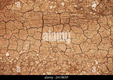 Masse rouge sèche fissurée.Texture et motifs de l'argile séchée surface fissurée de l'argile et de la terre. Banque D'Images