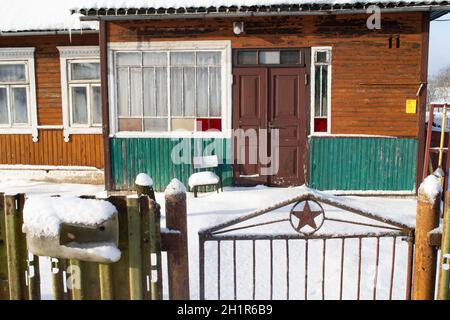 Façade d'un village biélorusse traditionnel ancienne maison en bois hiver avec clôture Banque D'Images