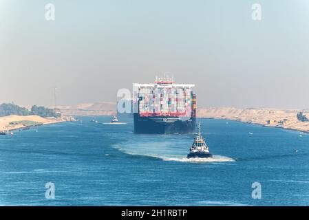 Ismailia, Egypte - Novembre 5, 2017 : grand navire porte-conteneurs MSC Maya passant Canal de Suez dans la brume de sable en Egypte. Remorqueur accompagne les navires. Banque D'Images