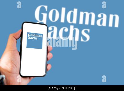 Rome, Italie, 16 février 2021 : main tenant un smartphone avec le logo Goldman Sachs à l'écran et logo Goldman Sachs flou en arrière-plan. Affaires Banque D'Images