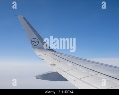 Aile gauche d'un Airbus A320-200 de Lufthansa German Airlines sur le vol numéro LH900 de Frankfurt TI London vu contre un ciel bleu et un cov de nuage blanc Banque D'Images