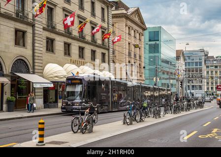 Genève, Suisse - 25 mai 2016 : tramway, bicyclettes et personnes sur la rue de la Corraterie avec drapeaux suisses dans le centre-ville, Genève, Suisse. Banque D'Images