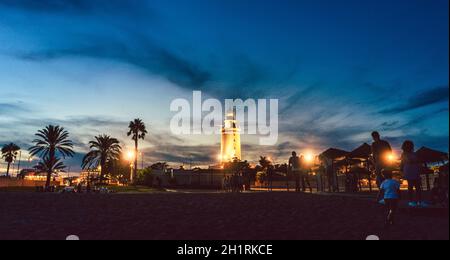 Phare dans la vieille partie du port de Malaga illuminé au crépuscule Banque D'Images