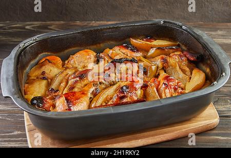 Cuisses de poulet au miel, aux raisins secs, aux pommes caramélisées et aux poires cuites au four Banque D'Images