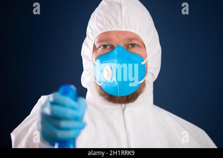 Pandémie de conavirus. Homme en costume entièrement protégé avec désinfectant pour la prévention et le contrôle des épidémies. Banque D'Images