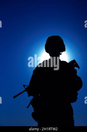 Silhouette du fusil d'assaut armé d'un soldat d'infanterie de l'armée sur fond de ciel nocturne avec lune.Les forces d'opérations spéciales combattent dans le casque de combat et u Banque D'Images