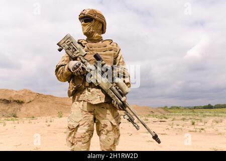 Soldat des forces spéciales entièrement équipé et armé avec fusil de sniper en gros plan. Banque D'Images