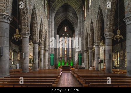 Killarney, Irlande, août 2019 intérieur, rangées de bancs, colonnes hautes, Vitraux et autel principal dans la cathédrale Saint-Marys Banque D'Images