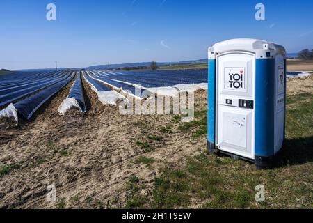 SCHROBENHAUSEN, ALLEMAGNE - MARS 31 : champ d'asperges avec des toilettes portatives, vu près de Schrobenhausen, Allemagne, le 31 mars 2021. Banque D'Images